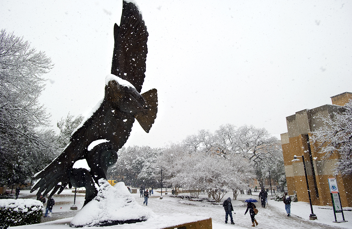 Eagle statue on campus during a snow day.